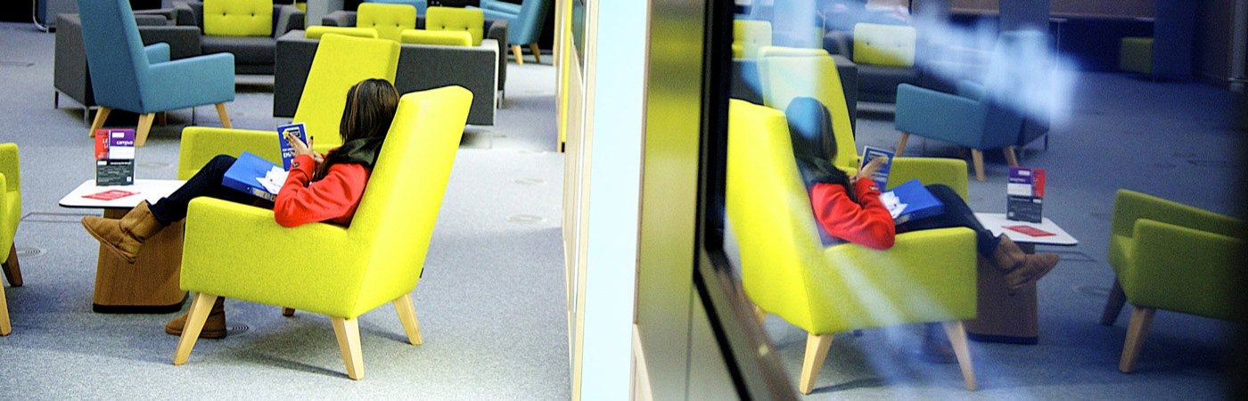 A student sitting in University Place Atrium at The University of Manchester